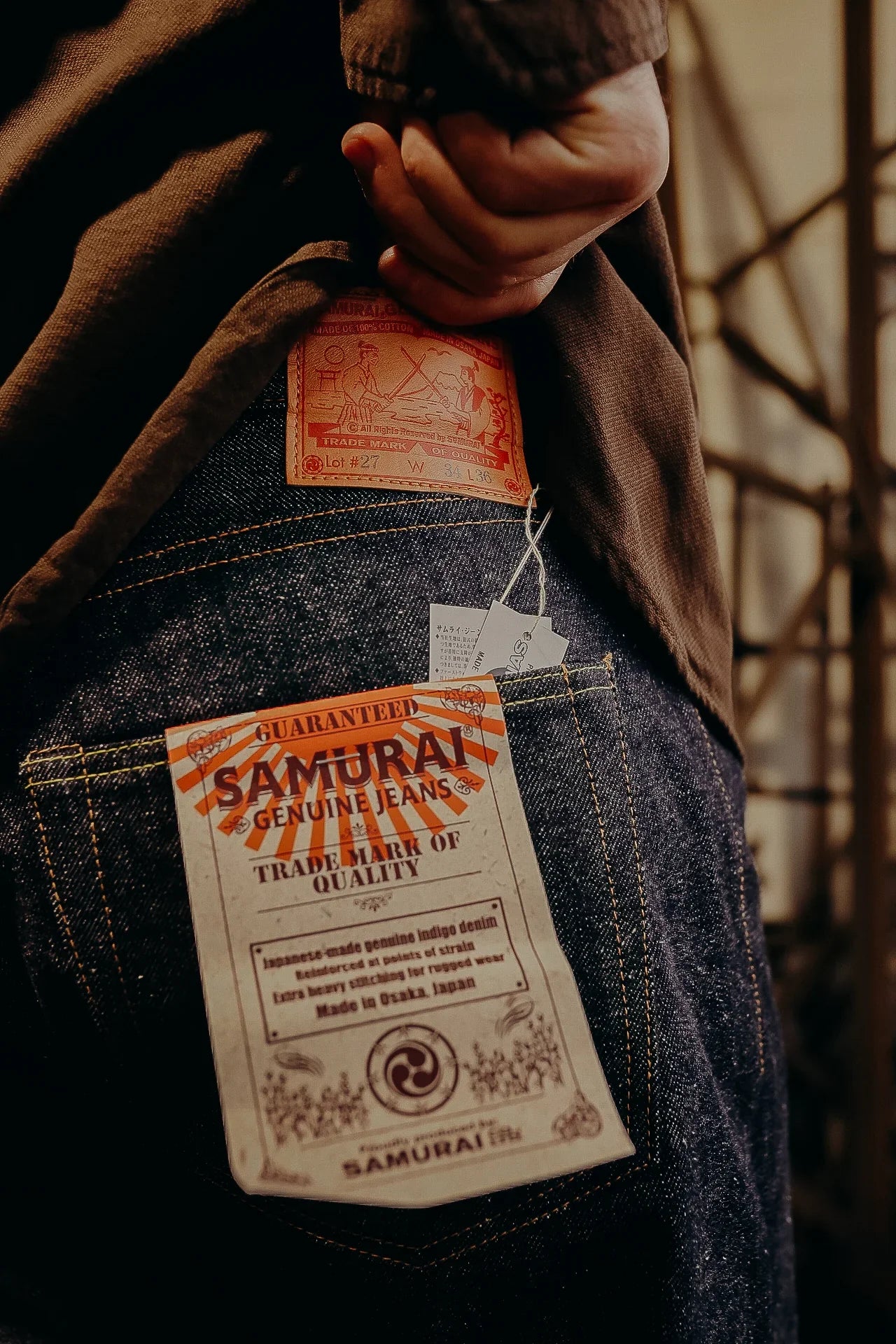Close-up of Samurai genuine indigo jeans with branded leather patch and quality guarantee tag
