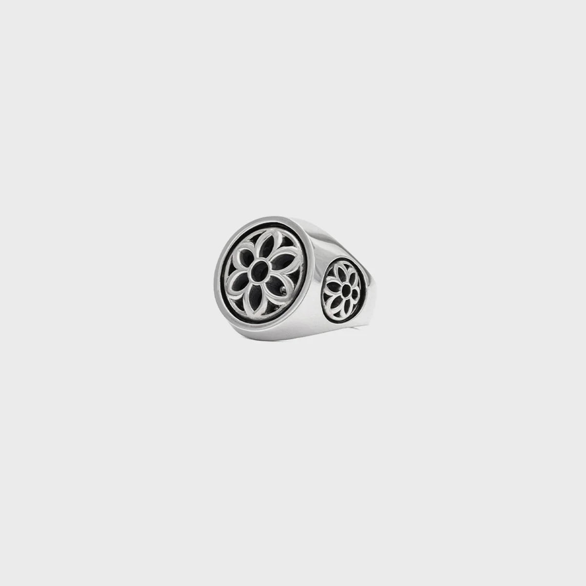 Silver club ring with black floral cutout design on front and sides against a gray background