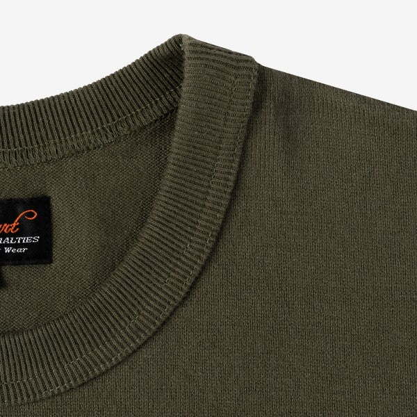 Close-up of olive green knit crew neck sweater collar with black and orange vintage-style label