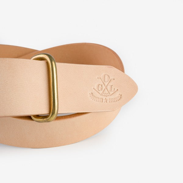 Close-up of natural leather belt with embossed logo and brass buckle from Iron Shop Provisions