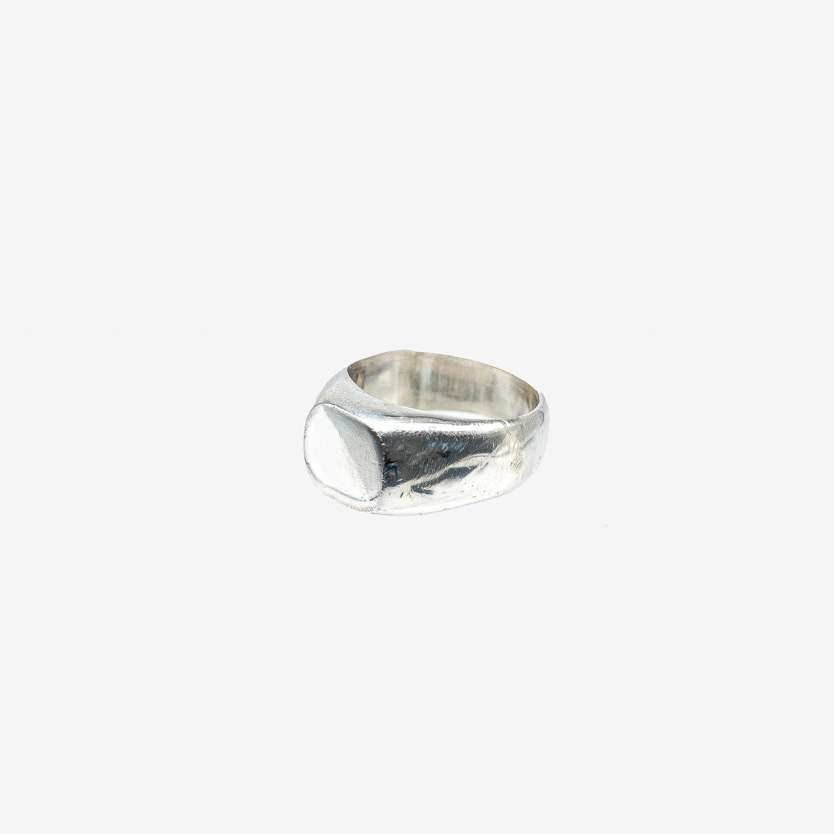 Minimalist hammered silver signet ring on white background from Iron Shop Provisions