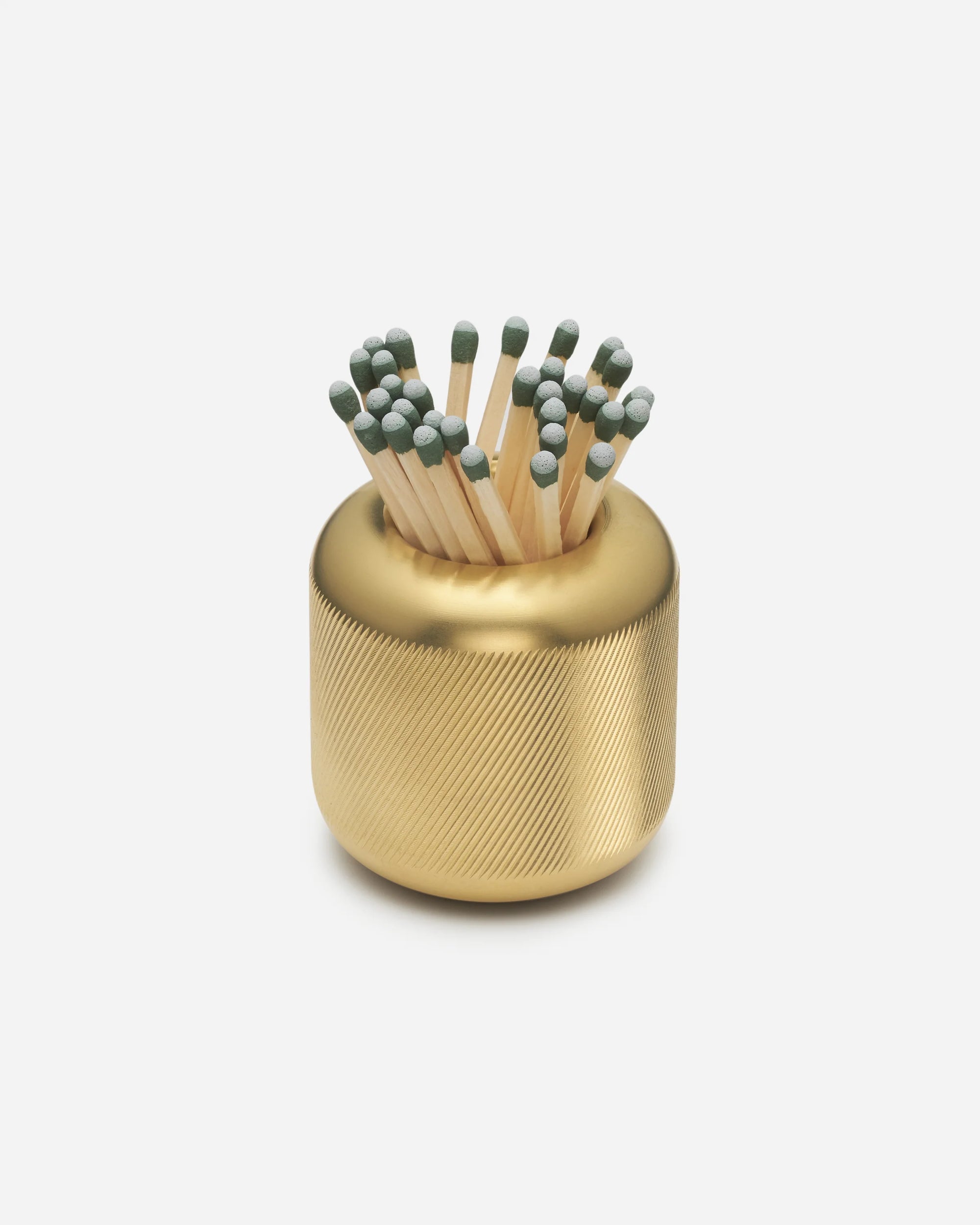 Golden metal matchstick holder filled with wooden matches with gray tips on a white background