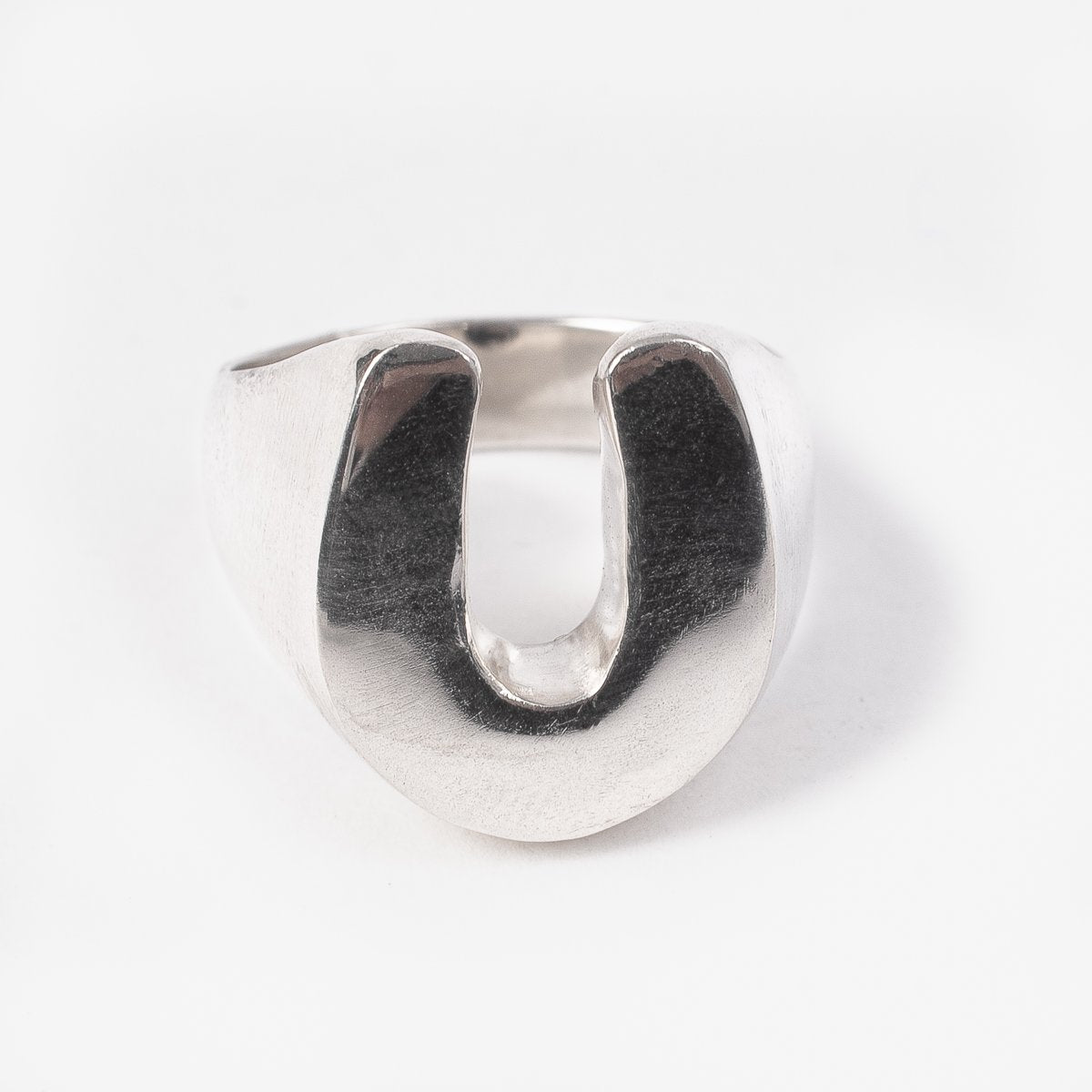 Polished silver iron ring with U-shaped open design on white background