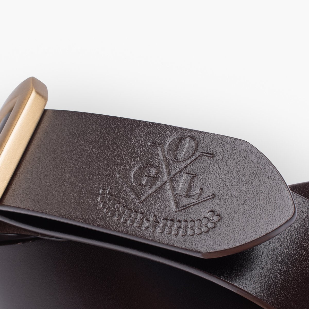 Close-up of dark brown leather belt with embossed logo and brass buckle, handcrafted accessory