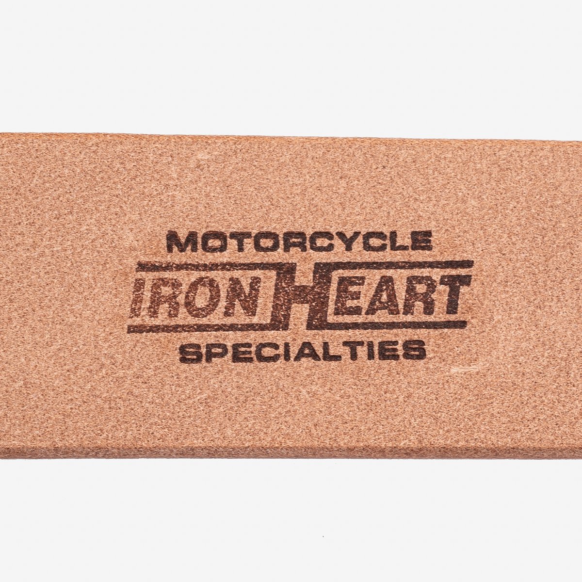 Close-up of a brown leather label with the stamped text 'Motorcycle Iron Heart Specialties'
