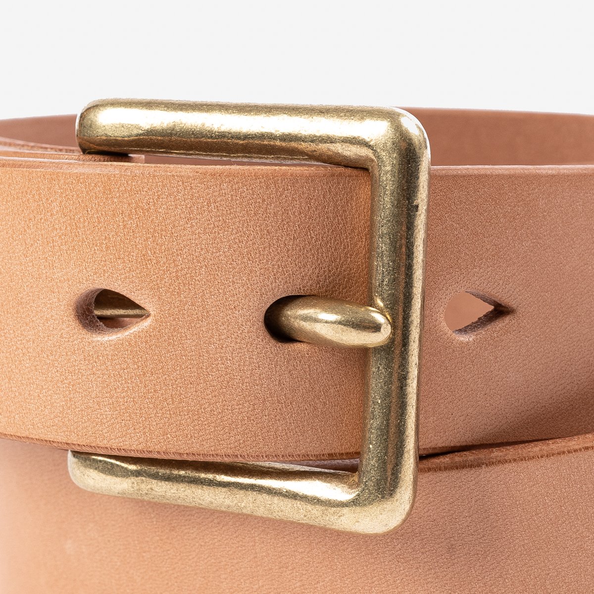 Close-up of a tan leather belt with a square brass buckle from Iron Shop Provisions