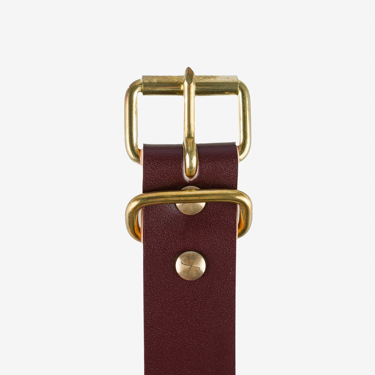 Close-up of a brown leather belt with brass buckle and hardware from Iron Shop Provisions