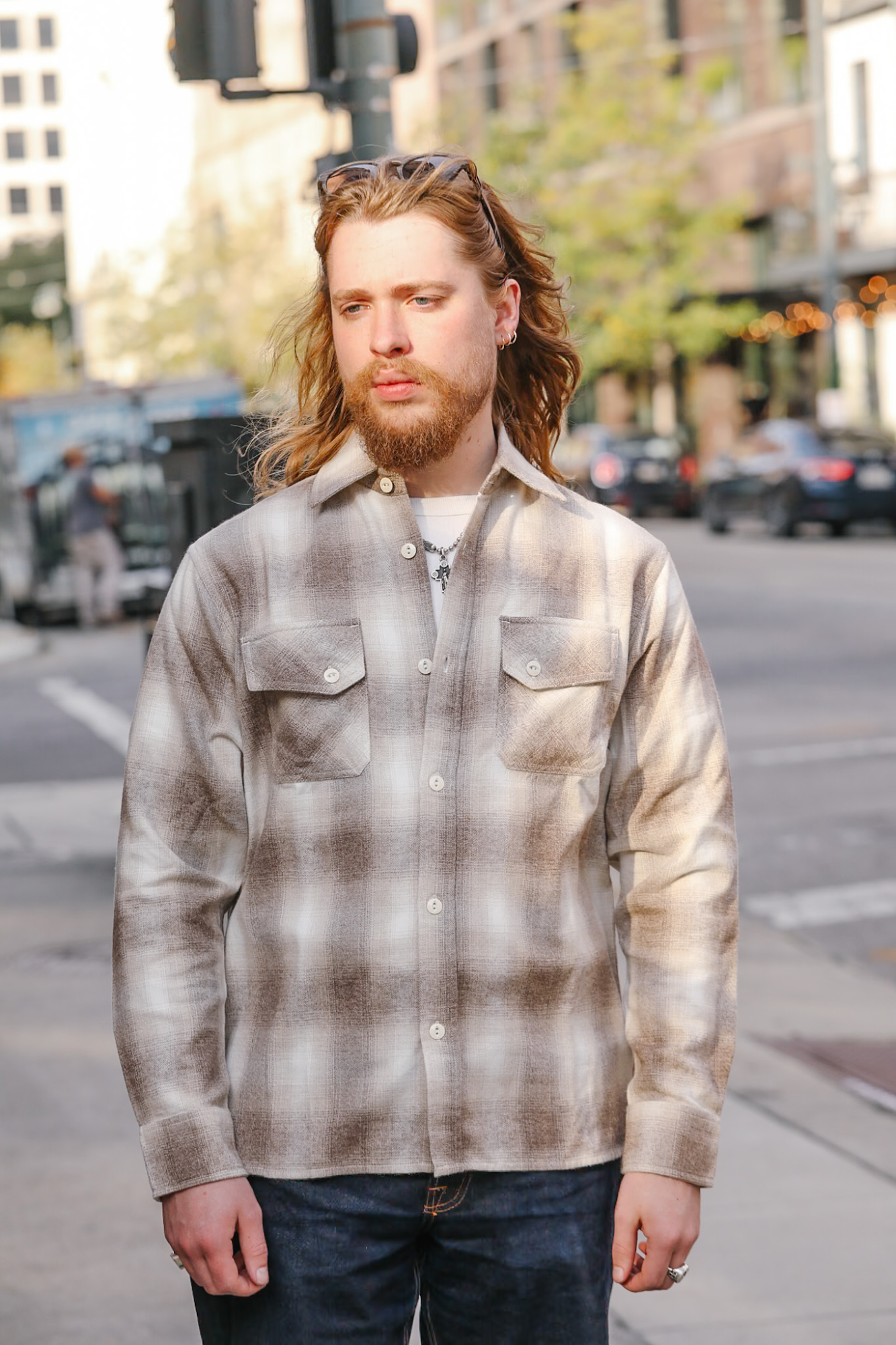 Man wearing a plaid shirt on a city street