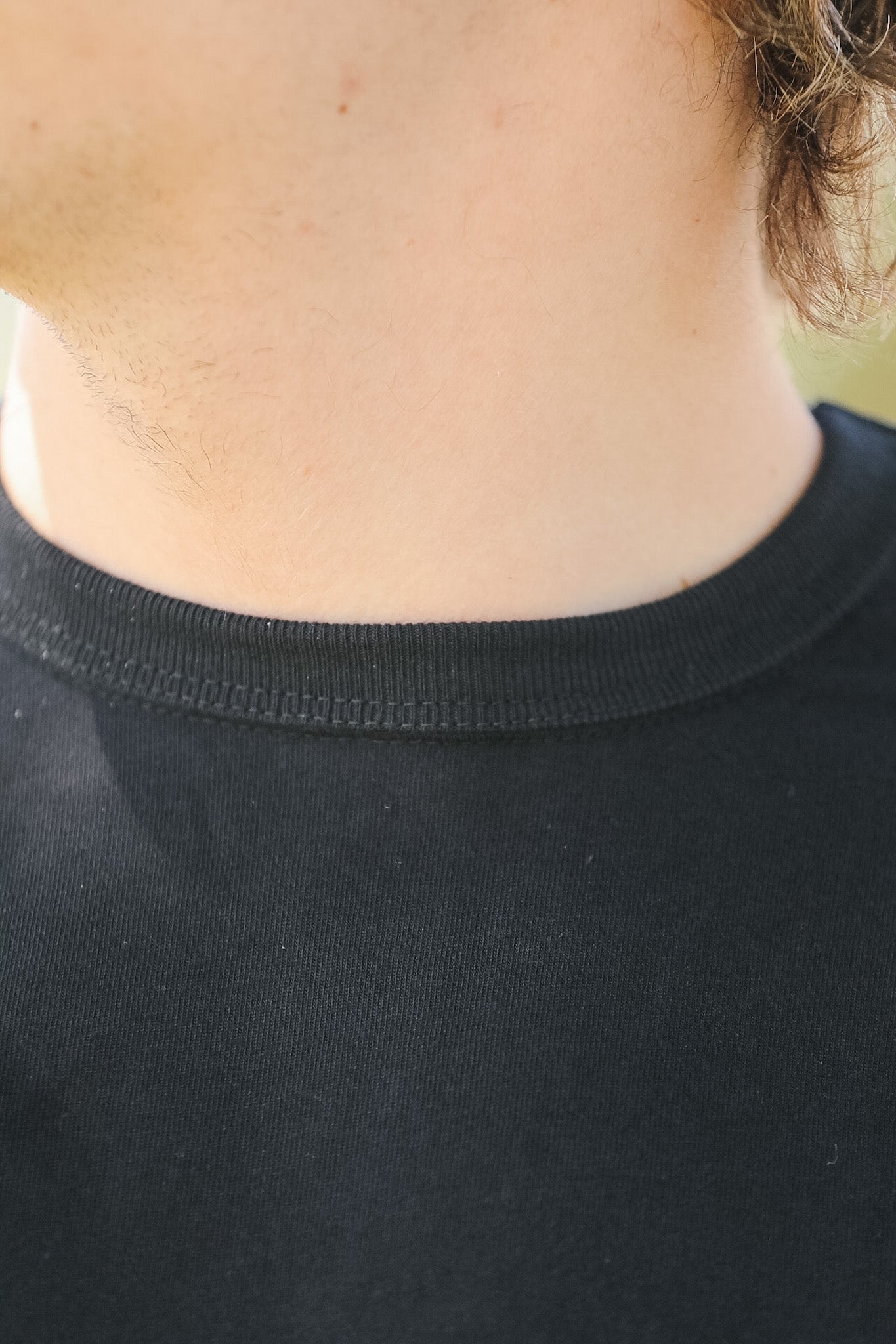 Close-up of a person wearing a black shirt with a blurred background