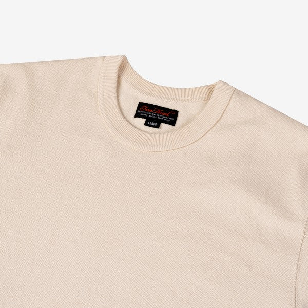 Close-up of cream-colored crewneck knit sweater with ribbed collar and black size label at Iron Shop Provisions