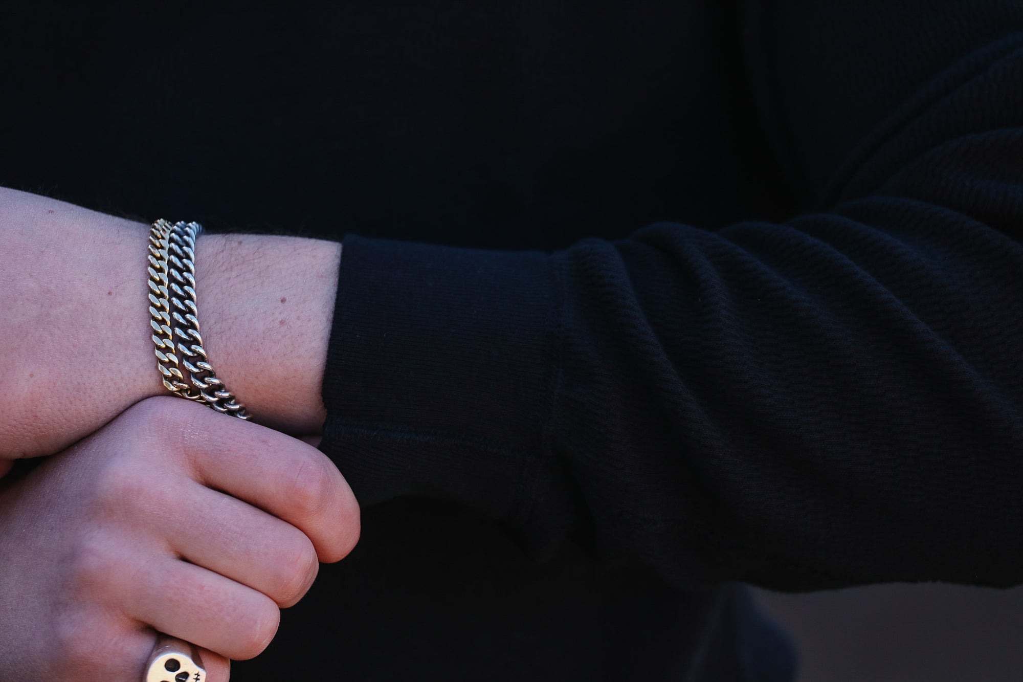 Gold chain bracelet on a wrist with a blurred background