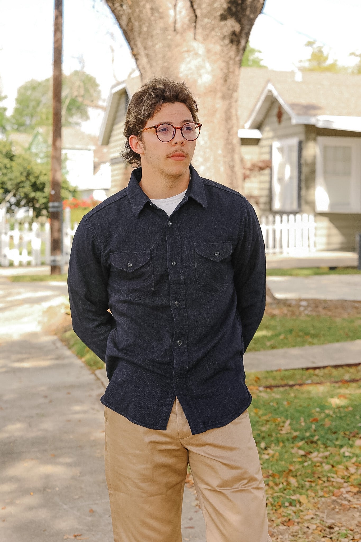 man wearing dark blue shirt on sidewalk