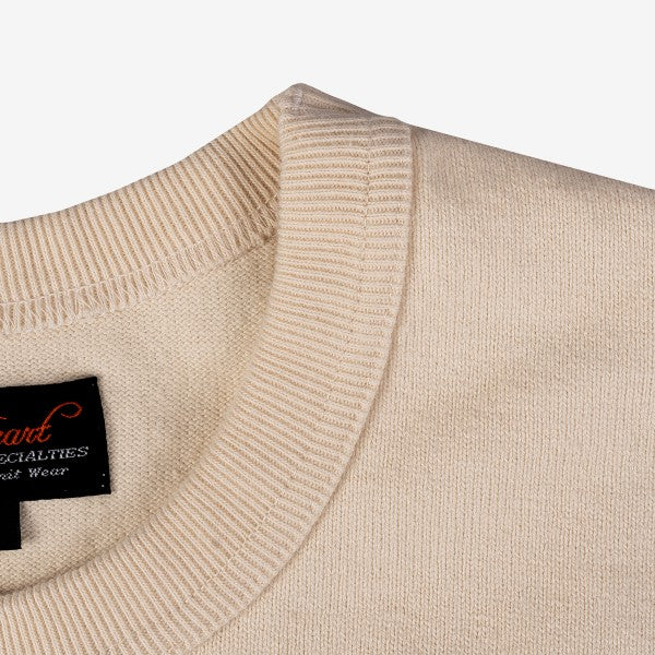 Close-up of cream beige ribbed crew neck sweater fabric and black clothing label