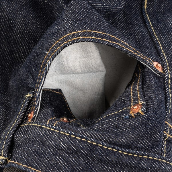 Close-up of dark denim jeans pocket with visible copper rivets and yellow stitching detail