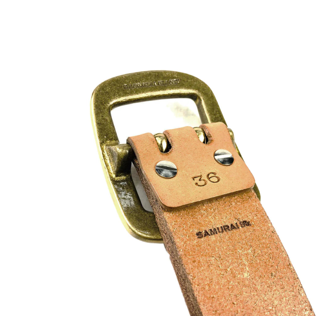 Close-up of natural leather belt strap with metal buckle stamped 'SAMURAI' and size 36