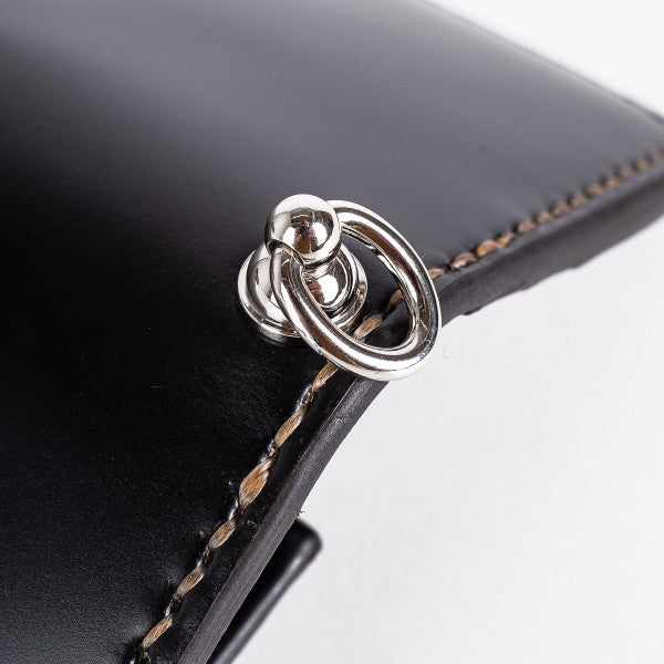 Close-up of black leather with brown stitching and silver metal tie ring detail at Iron Shop Provisions