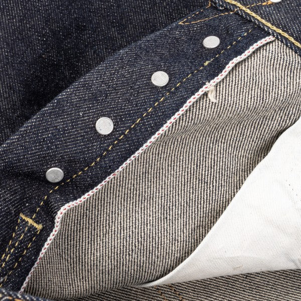 Close-up of premium selvedge denim jeans with copper rivets and yellow stitching detail