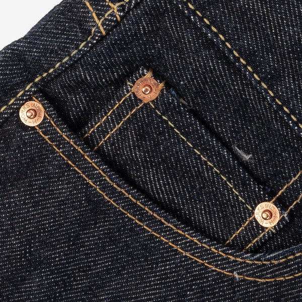 Close-up of dark denim jeans pocket with orange stitching and copper rivets from Iron Shop Provisions