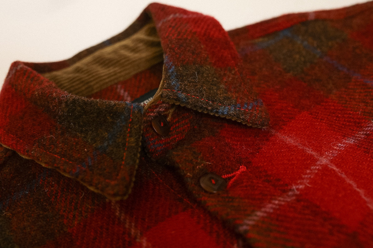 Close-up of a red plaid shirt with a collar and button details.