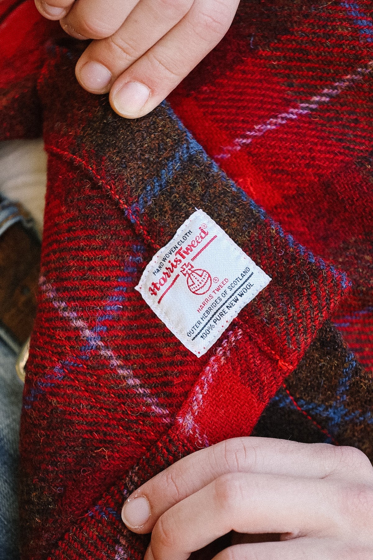Red plaid fabric with a label held by hands