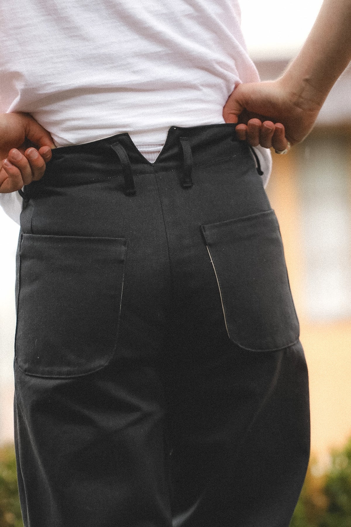 Person wearing a black apron with a blurred background