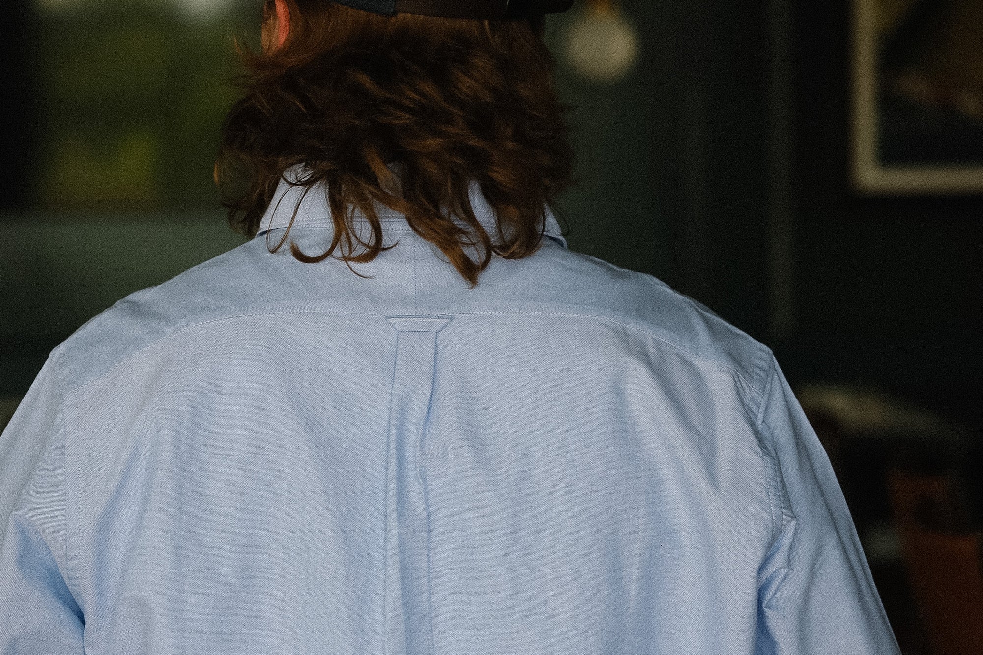 Person wearing a light blue shirt with a blurred background