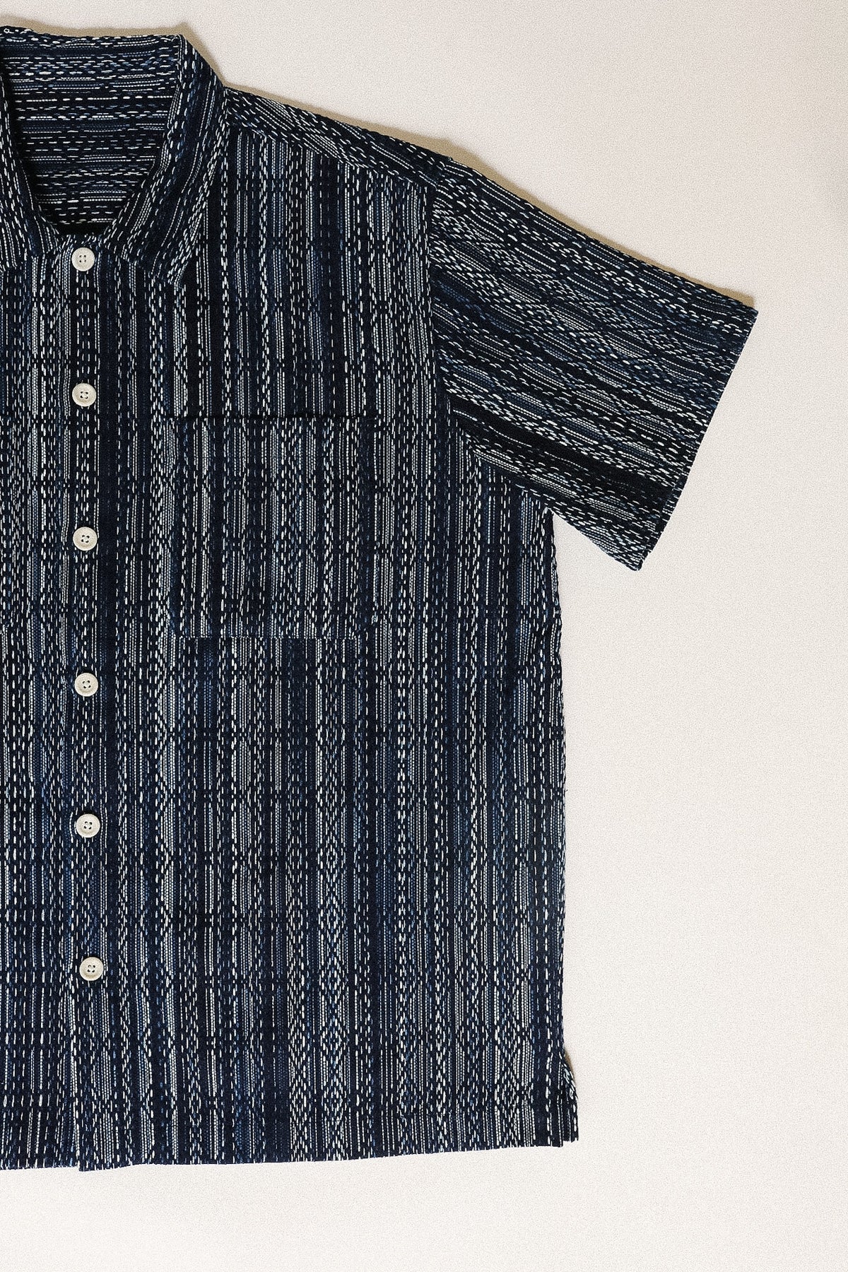 Dark blue patterned shirt on a light beige background