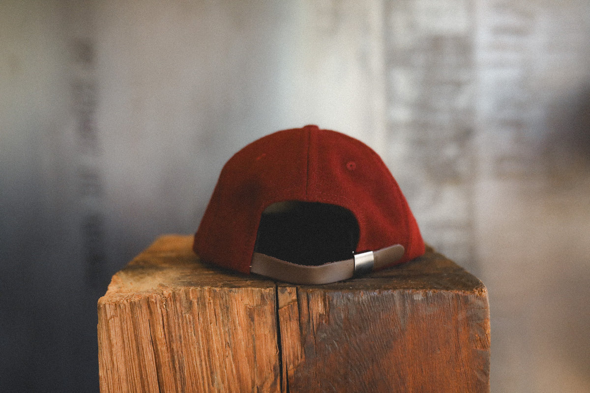 Dark maroon baseball cap on a wood block 