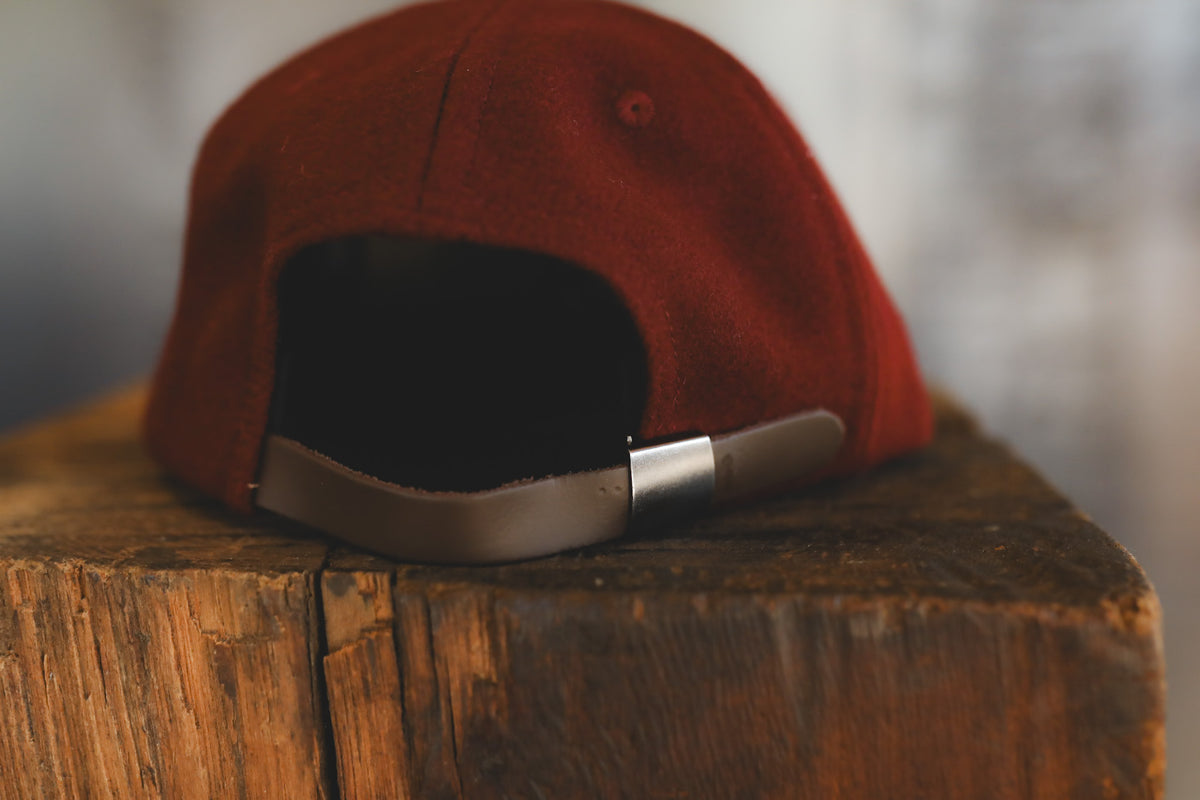 Dark maroon baseball cap on a wood block 
