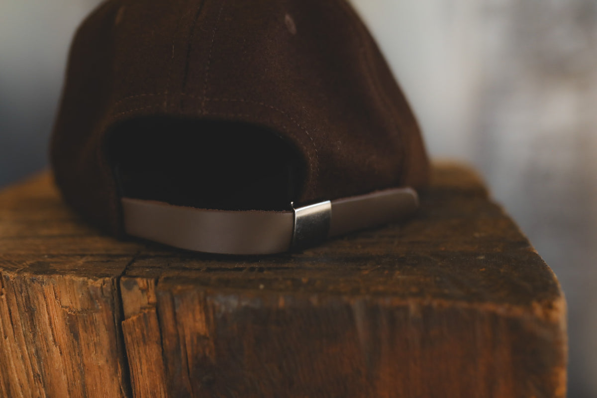 Up close of a brown baseball cap with branding 