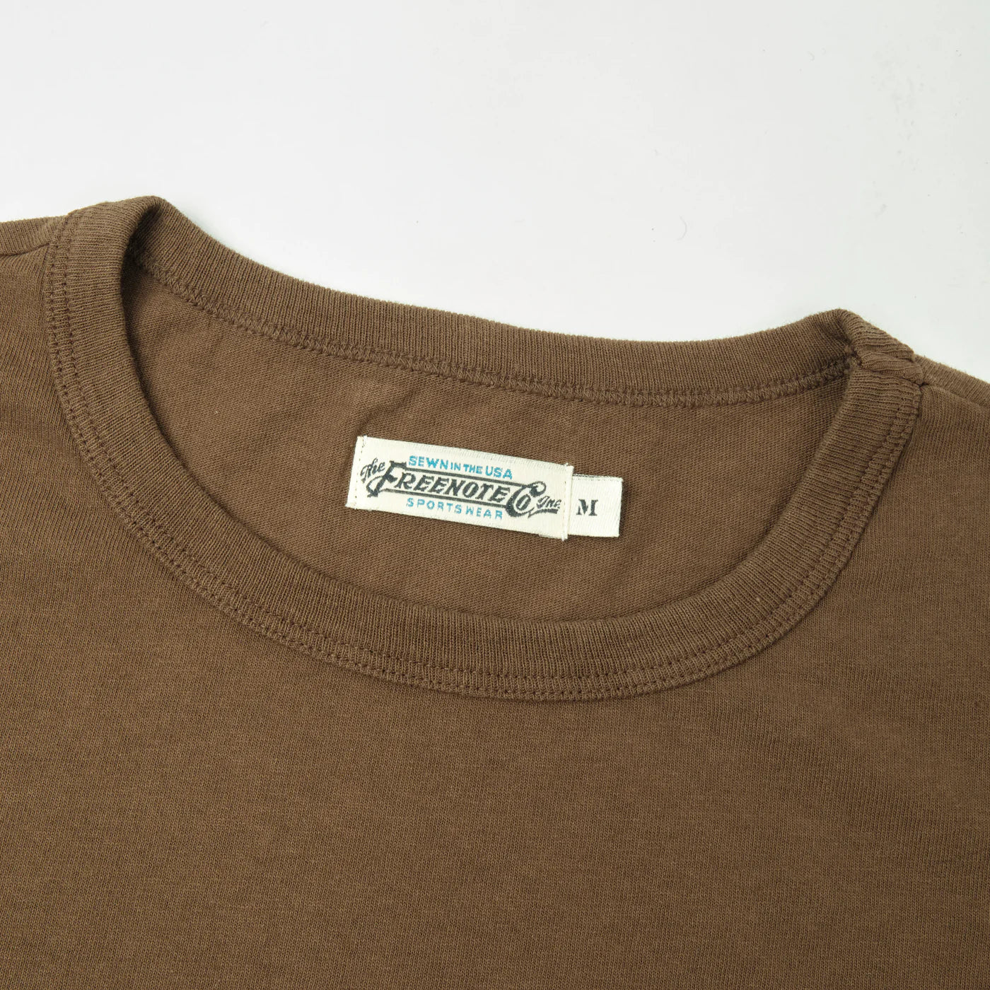 Close-up of brown crewneck t-shirt collar with Freenote Co. sewn label, size medium