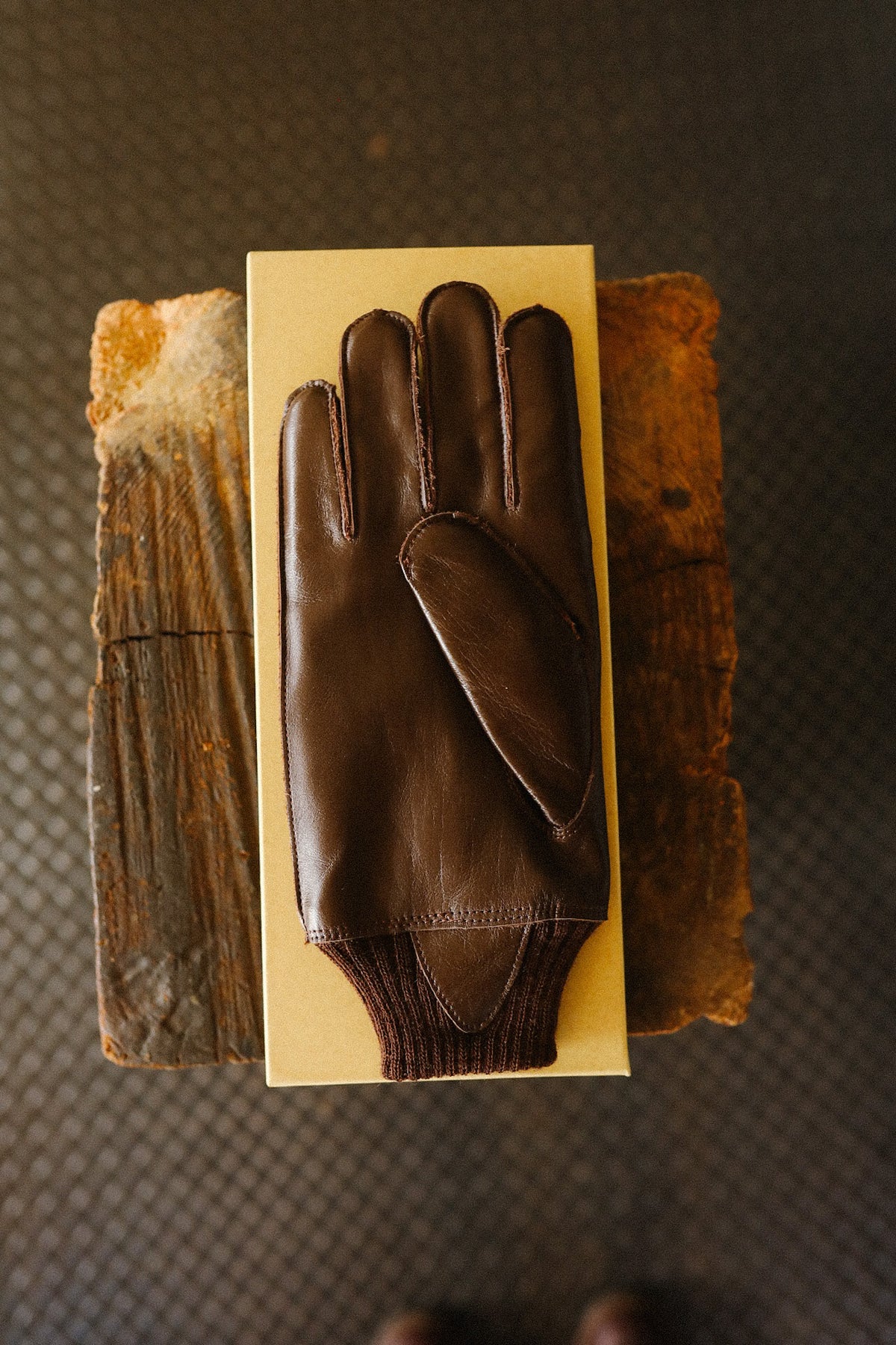 brown leather gloves on a yellow background