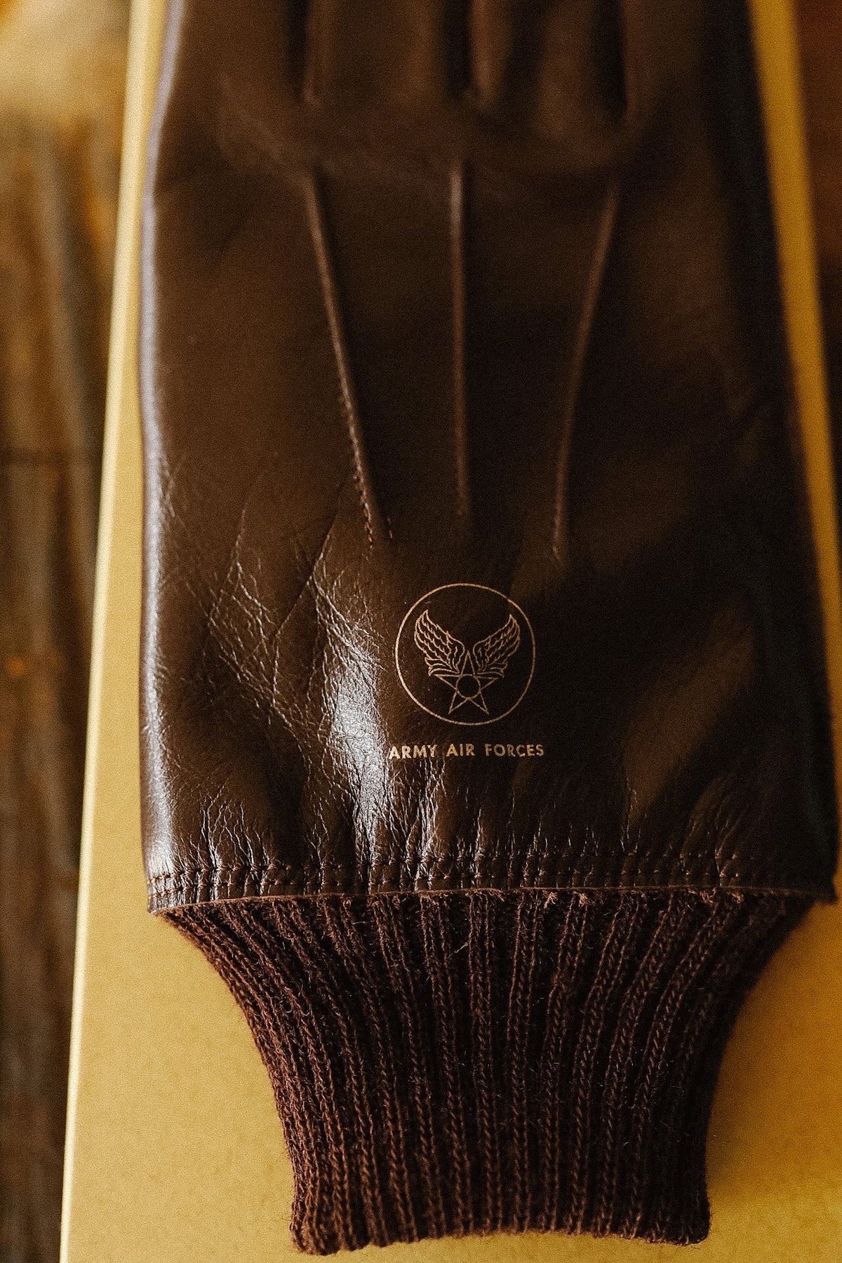 brown leather gloves on a yellow background