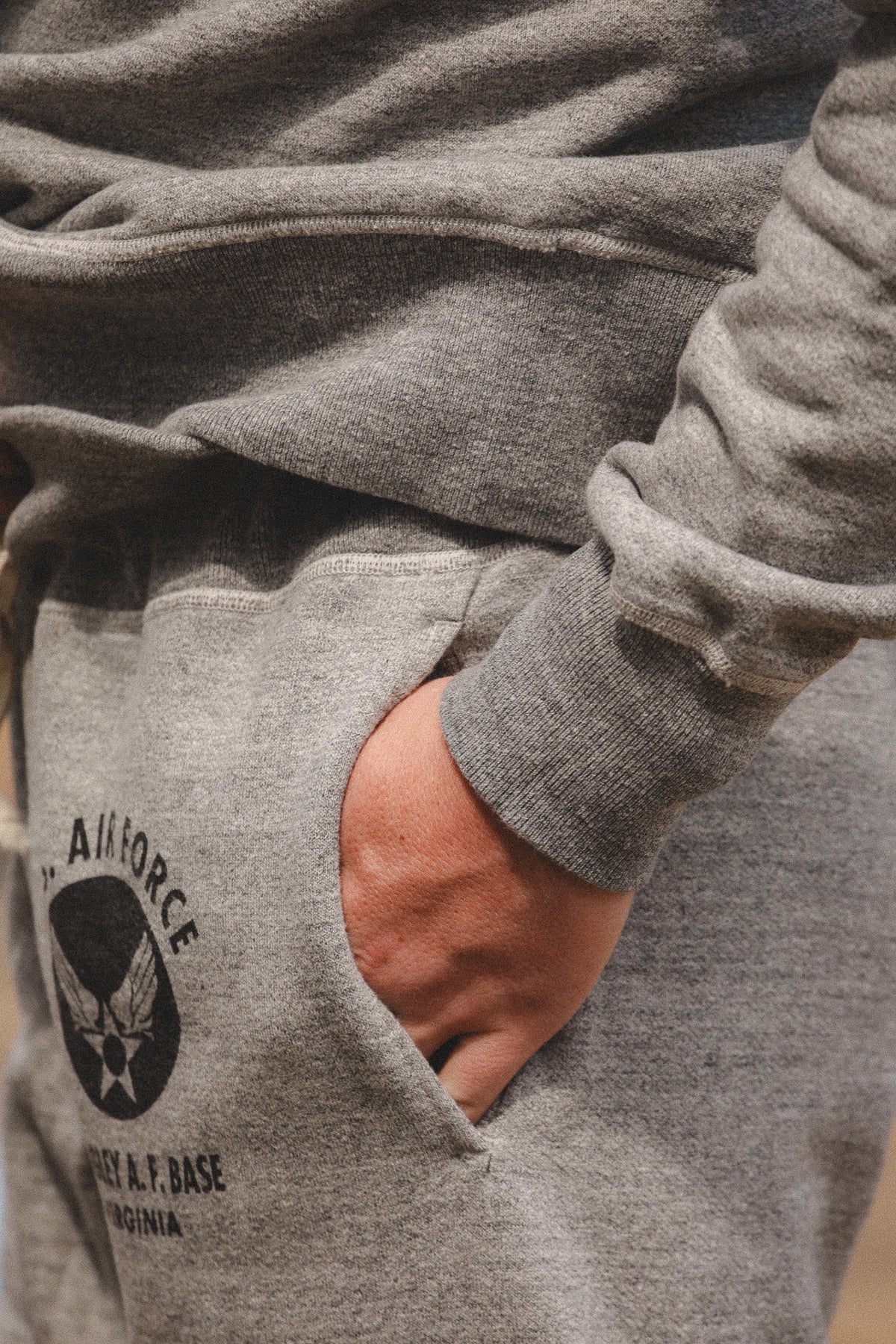 Close-up of a person wearing heather gray sweatpants with a black U.S.