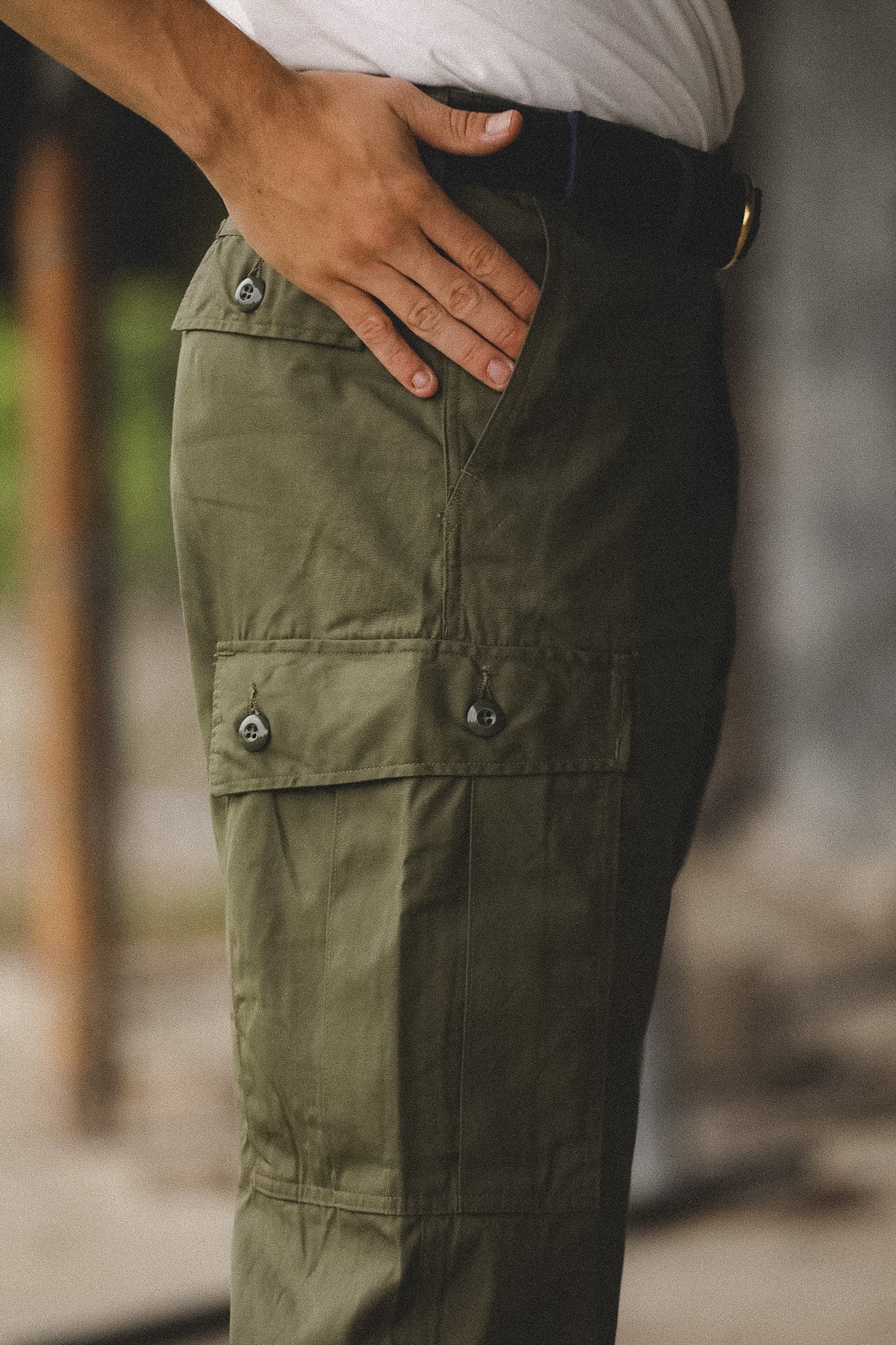 Person wearing olive green cargo pants with a blurred background