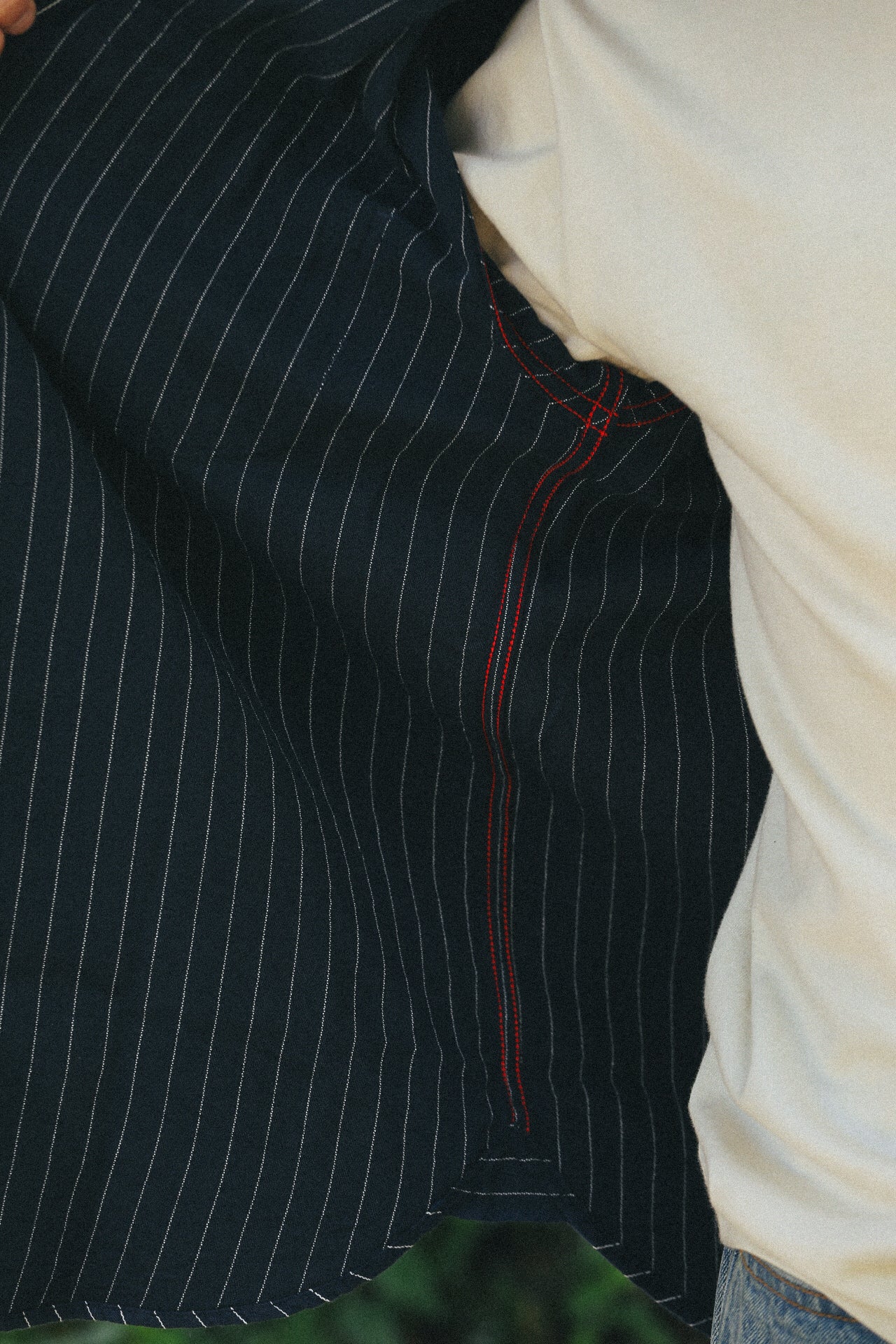 Navy blue pinstripe work shirt with red stitching detail worn over white shirt and jeans