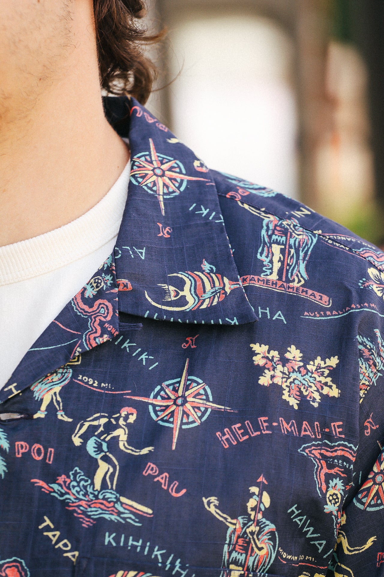 Close-up of navy cotton linen Hawaiian shirt with colorful vintage map and surfing print