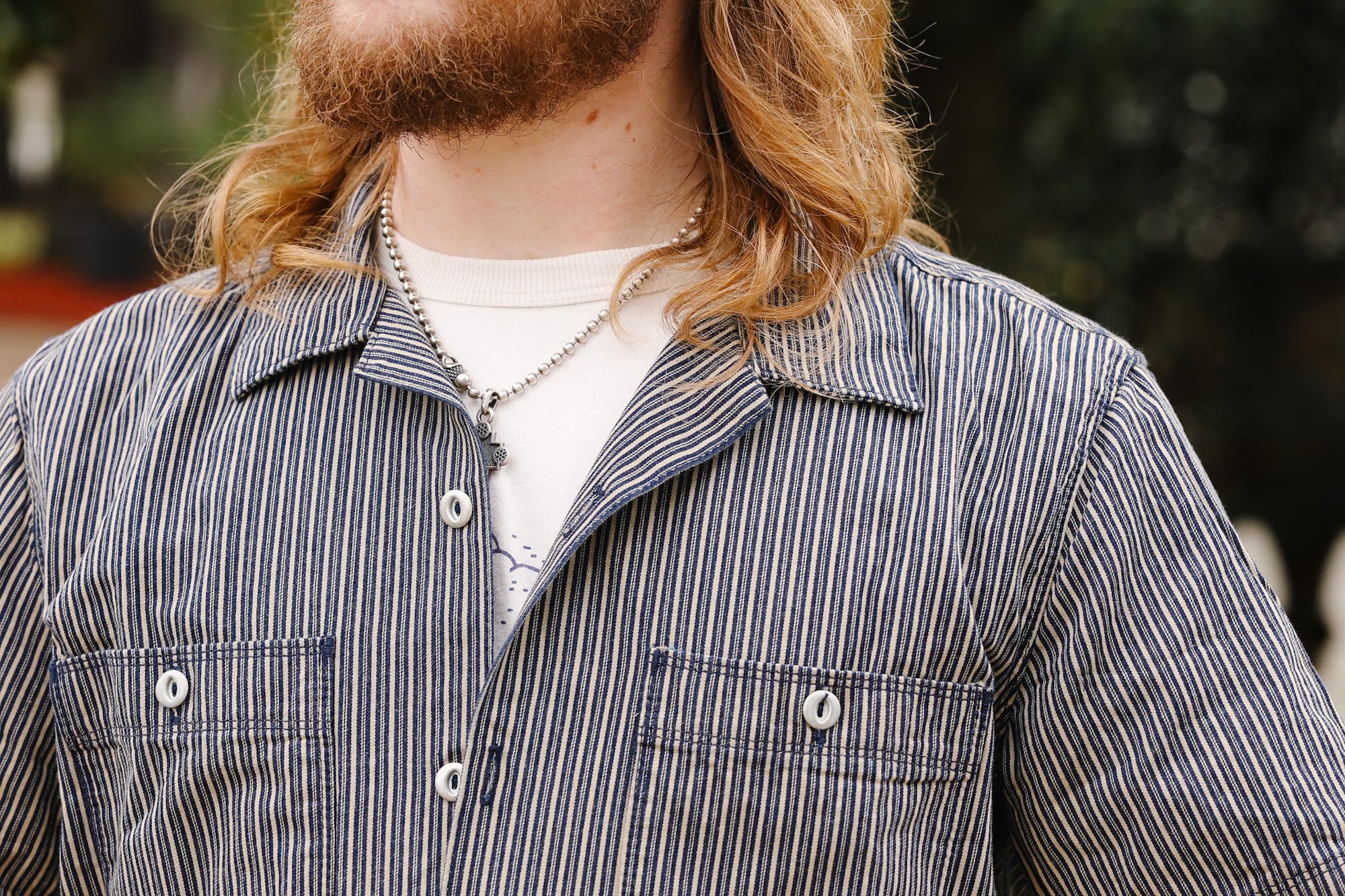 Person wearing a striped shirt with a blurred background