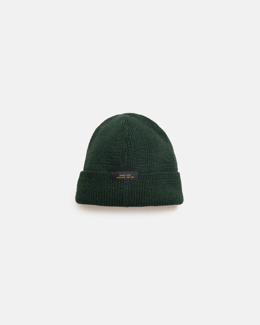 Dark green wool knit watch cap beanie with folded cuff and small black label on front