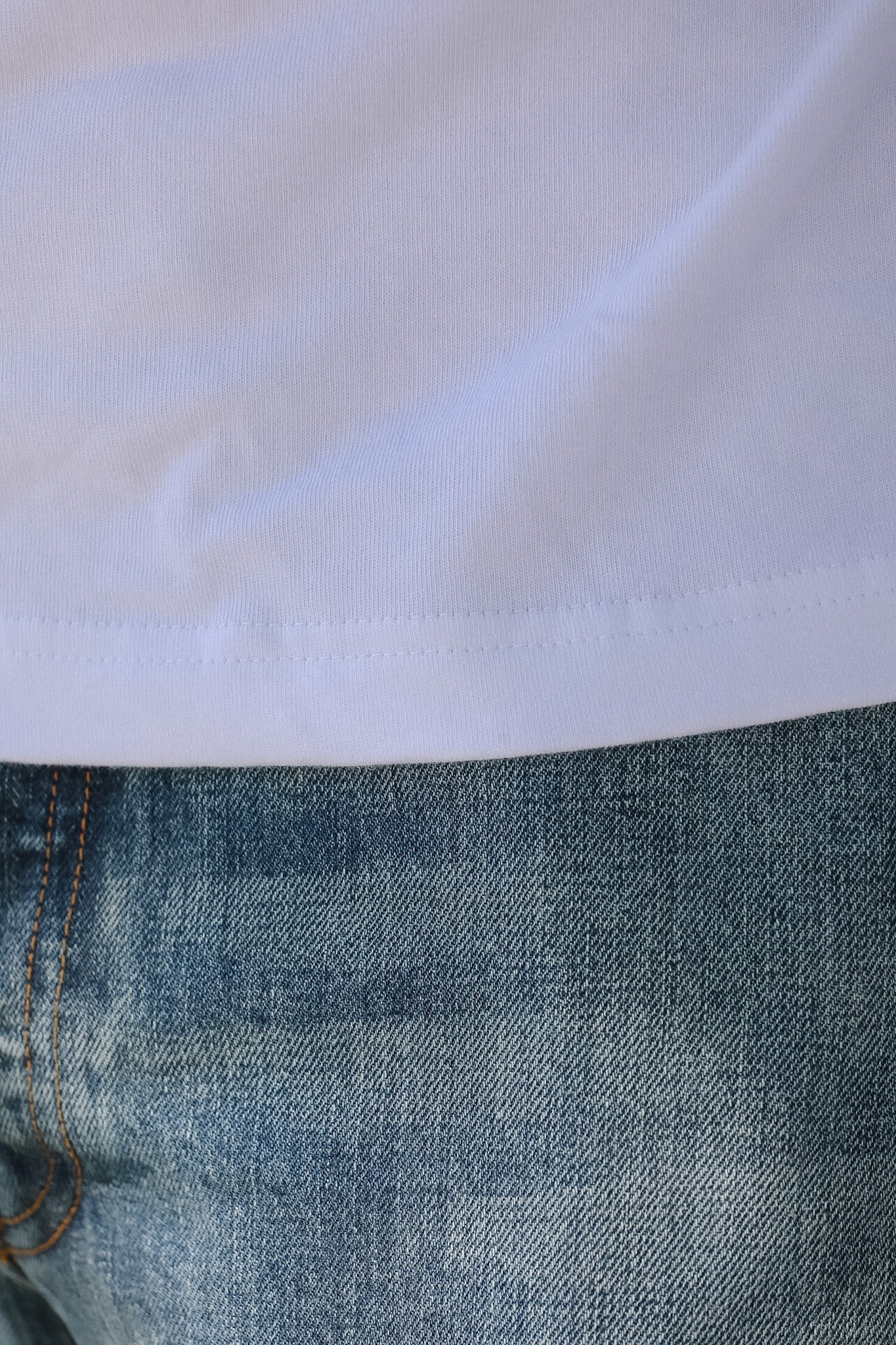 Close-up of blue jeans with a white fabric background