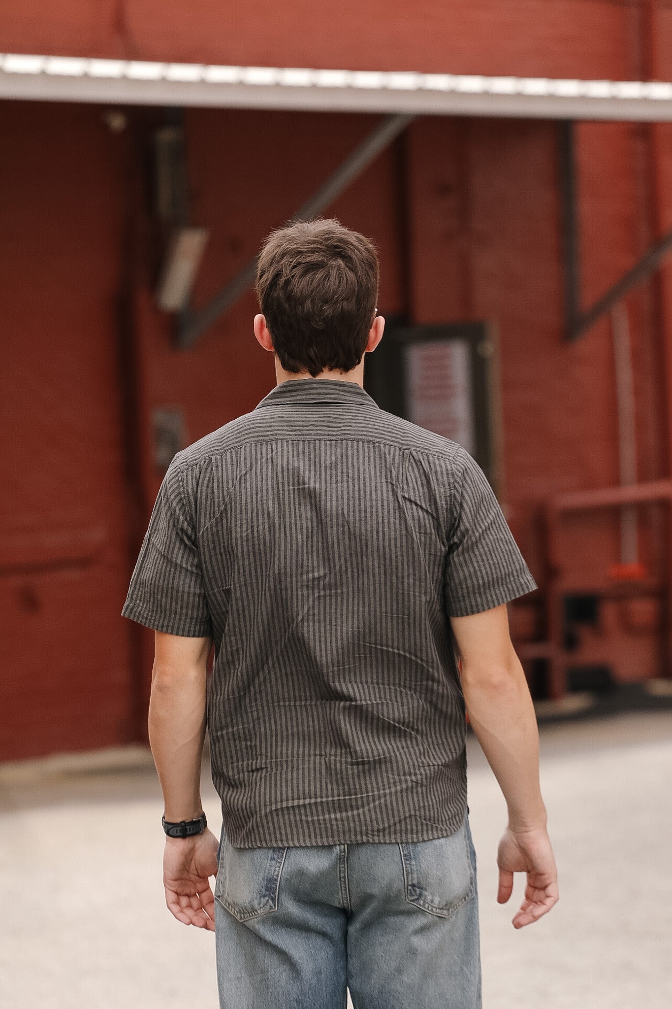Man walking away from a red barn door