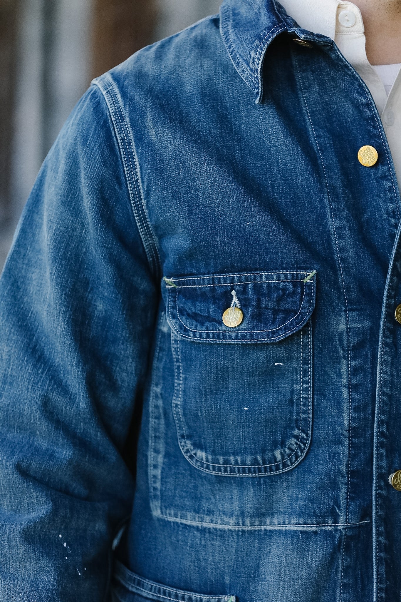 Close-up of a blue denim jacket with gold buttons.