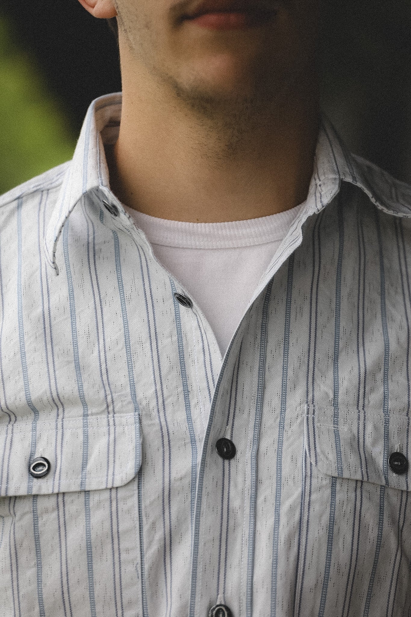 Close-up of a person wearing a striped shirt with a blurred background