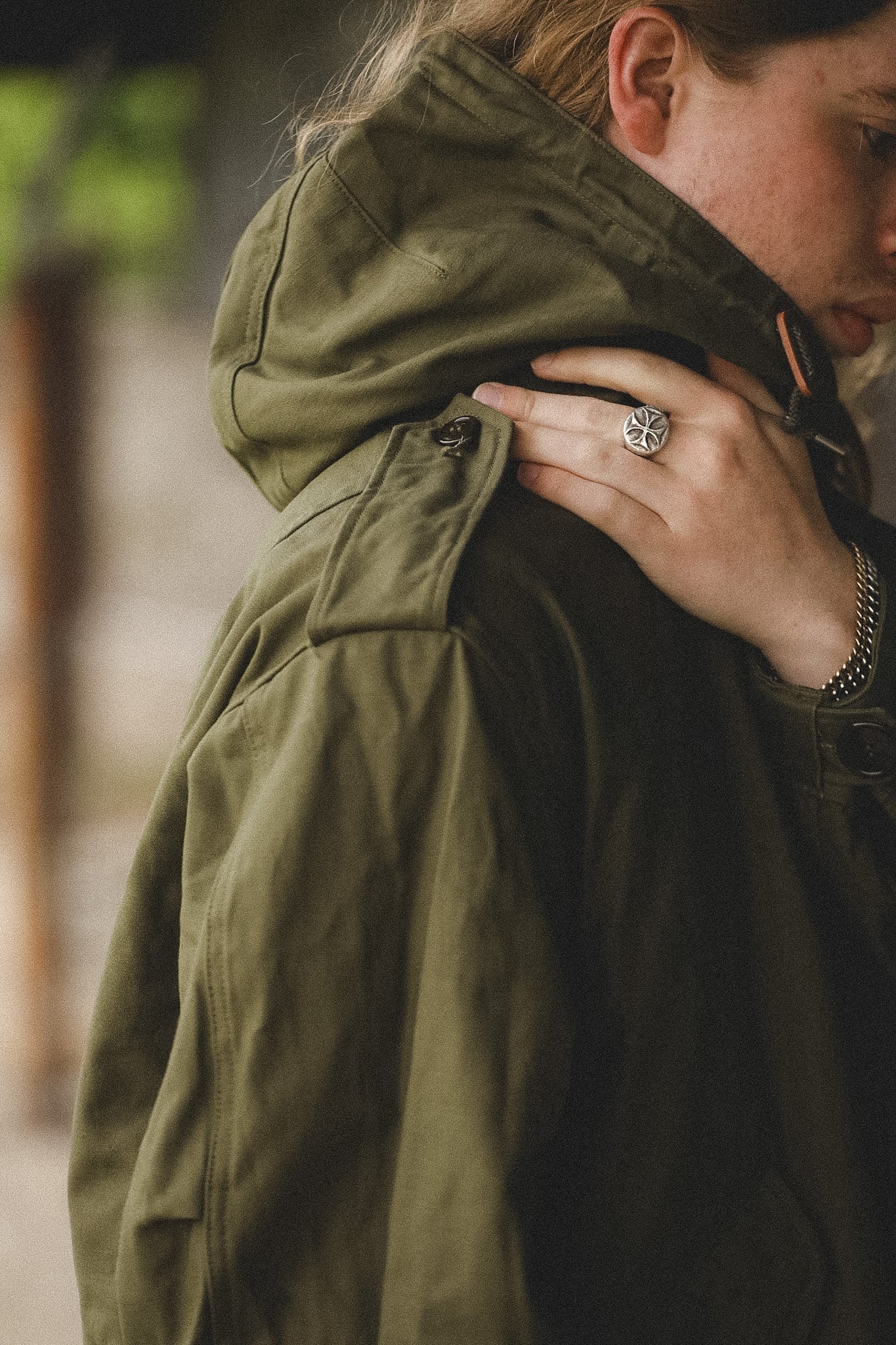 Person wearing a green jacket with a blurred background