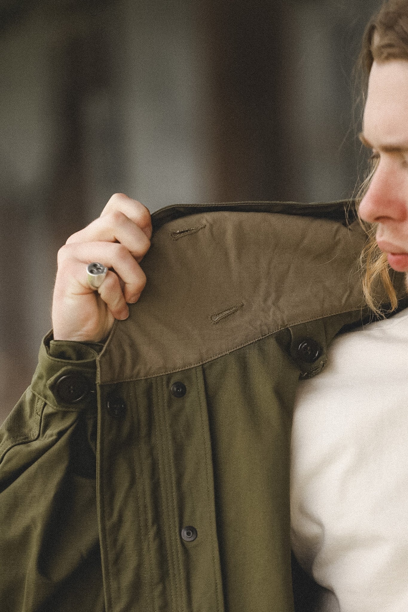 Person wearing a green jacket with a blurred background
