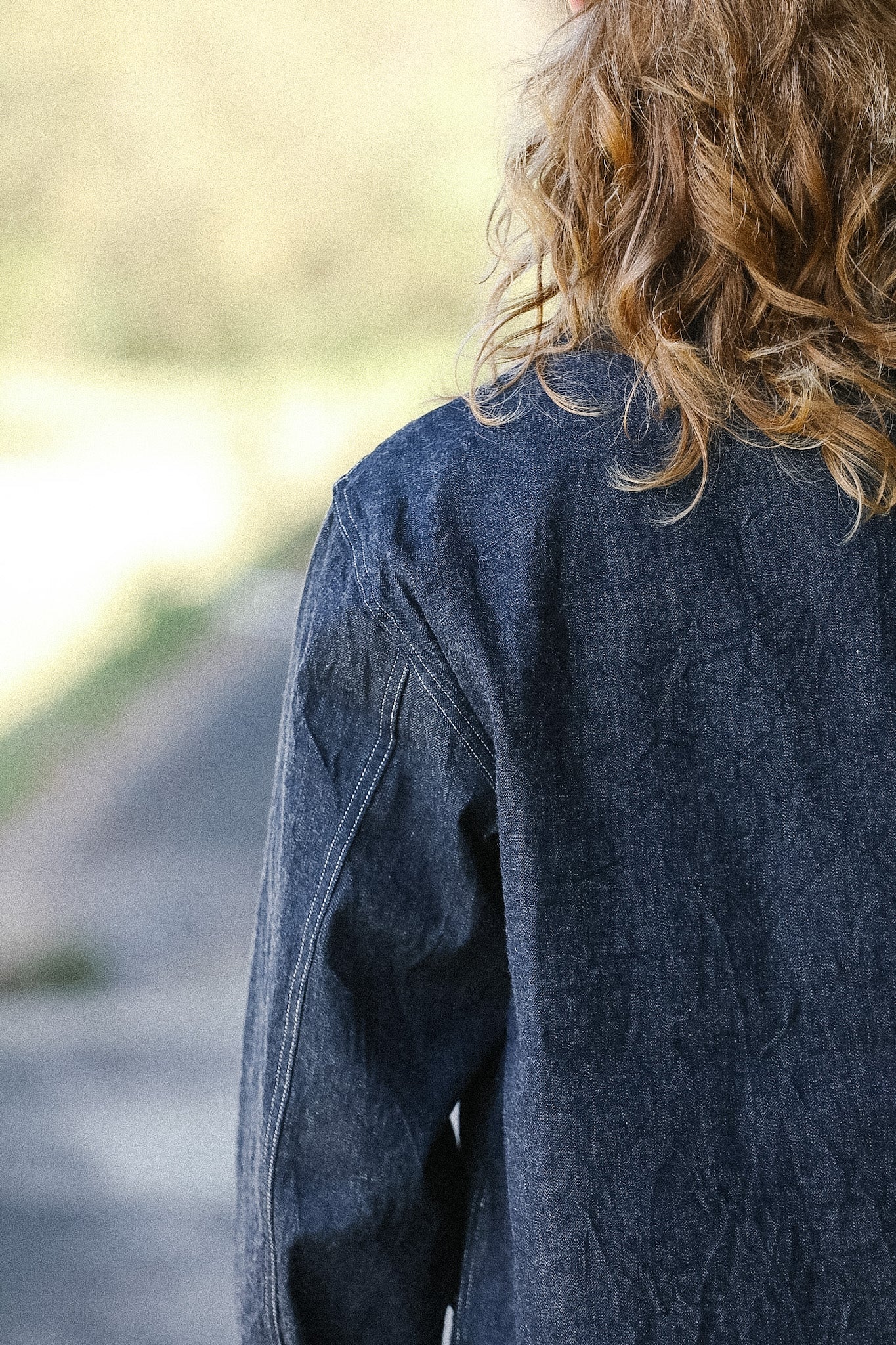 Person wearing a blue denim jacket with a blurred background