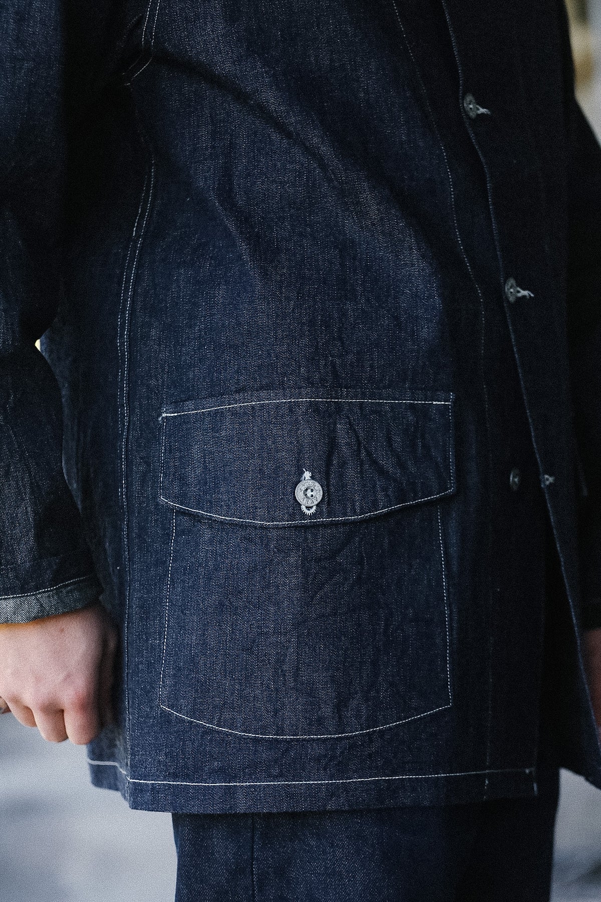 Close-up of a dark denim jacket with a pocket detail.