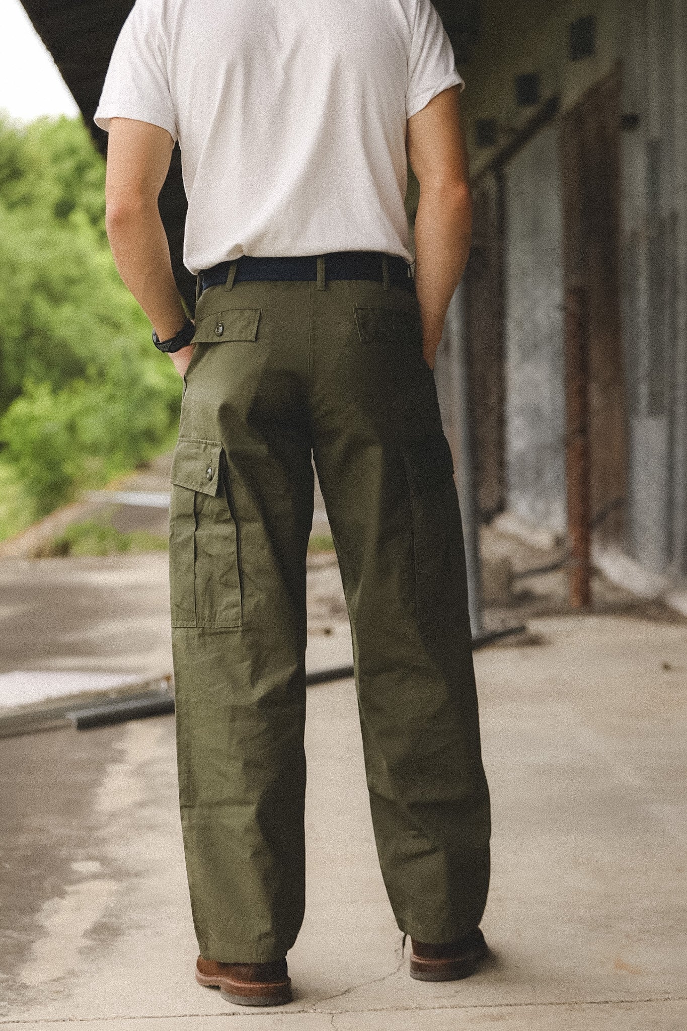 Person wearing green cargo pants and a white shirt in an urban setting