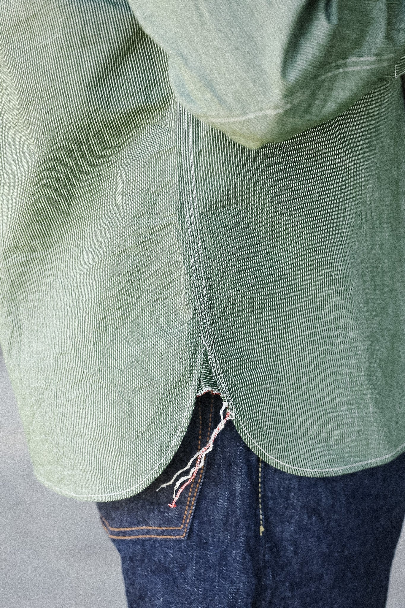 Green jacket and blue jeans on a plain background