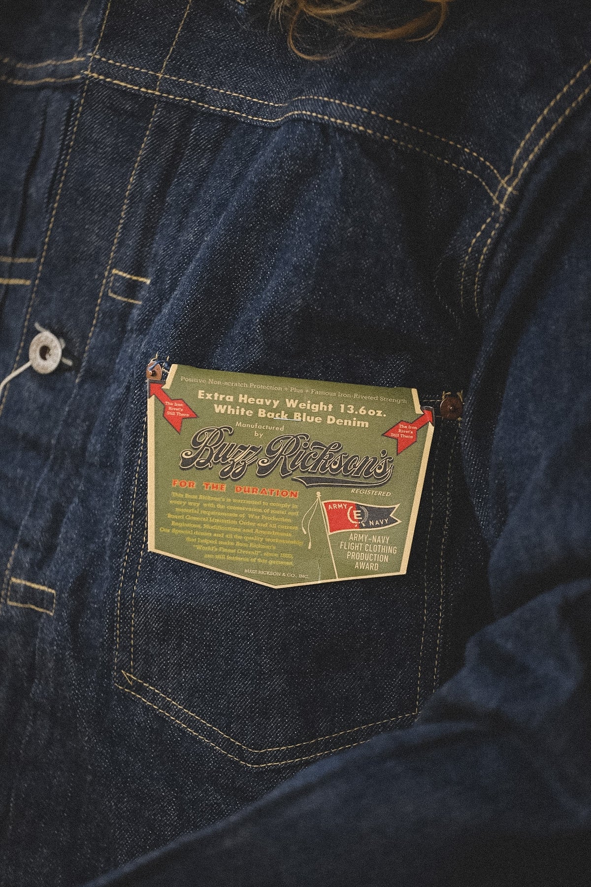 Close-up of a denim jacket pocket with a brand label.